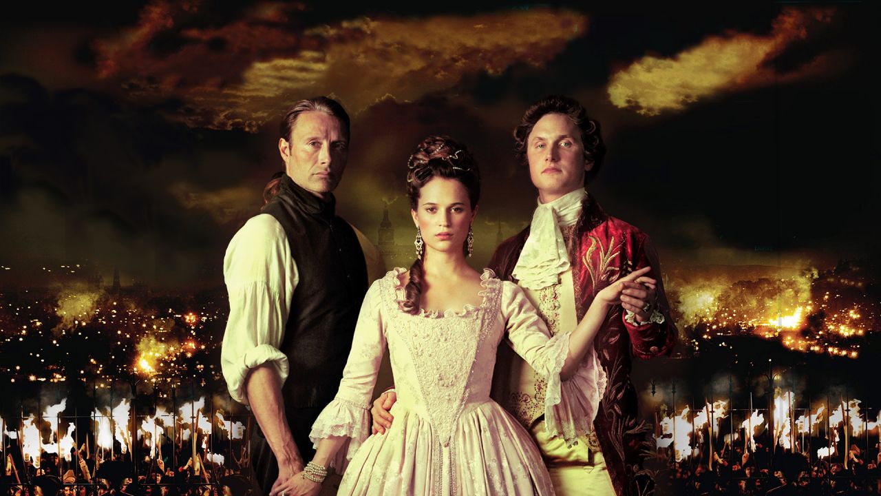 Königin Caroline Mathilde (Alicia Vikander) zwischen Struensee (Mads Mikkelsen) und König Christian VII. (Mikkel Boe Følsgaard) vor brennender Stadt. (Bild: rbb/ MFA+ Film Distribution) 