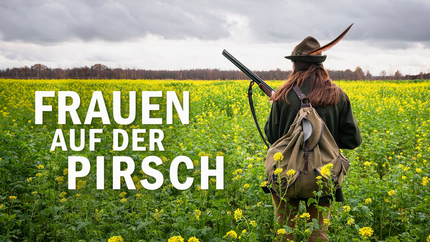 Eine junge Jägerin steht während einer Treibjagd in einem gelb blühenden Feld. (Bild: IMAGO/Countrypixel)