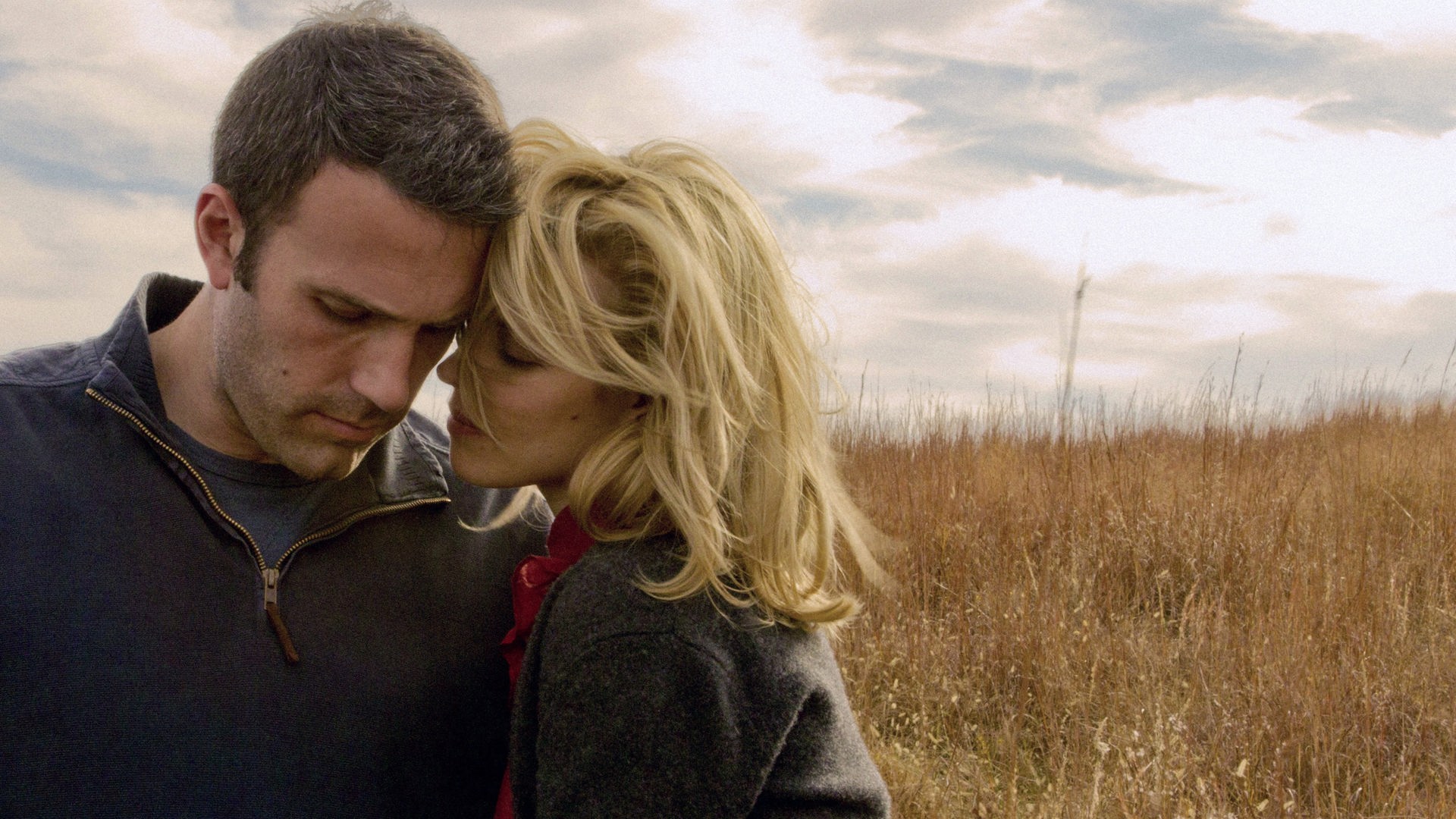 Ben Affleck und Rachel McAdams in einer innigen Szene aus „To the Wonder – Die Wege der Liebe“: Stirn an Stirn auf einer Herbst-Wiese..