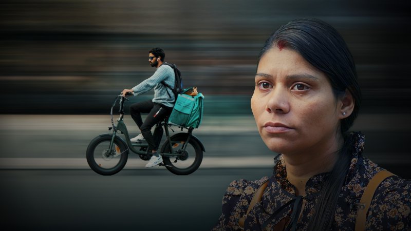 Junge Frau mit ernstem, besorgtem Blick im Vordergrund, dahinter unscharf ein Fahrradkurier mit grünem Lieferrucksack in der Stadt.
