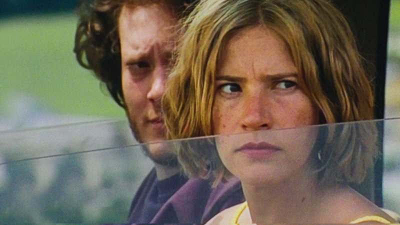 Diana (Sara Summa) und Arthur (Robin Summa) schauen über halbgeöffnete Seitenscheibe aus dem Auto