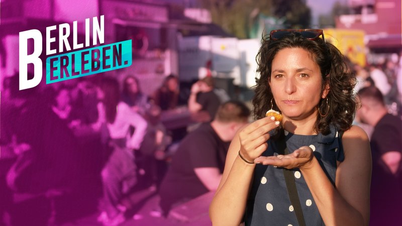 Eine Marktbesucherin beißt in ein Gebäckstück. (Bild: rbb/Maximilian Fischer) 